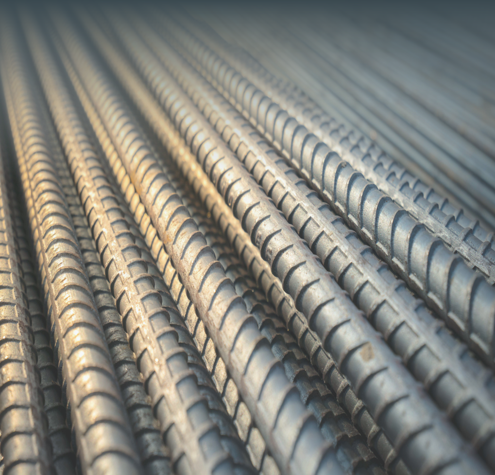 Stacked metal ingots arranged in rows on a warehouse floor. The environment is industrial and organized, conveying a sense of strength and reliability. Visible text: Metals and Others. The tone is professional and confident.